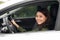 Alluring young woman driving the car and smiling