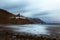 Almaciga village on rocky coastline during stormy weather.