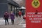 Almaty / Kazakhstan - 11.20.2020 : People walk down the street in snowy weather against the background of a warning poster about