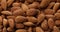 Almond close-up. Brown nuts rotate and stack. Natural vegetarian food. Walnut background.