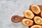 Almond cookies and raw almonds on wooden cutting board over white background, close-up, selective focus.