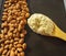 Almond flour in a wooden spoon on a background of nuts almonds.