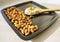 Almond flour in a wooden spoon on a background of nuts almonds.