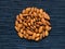 Almond pile on dark background. Almond macro photo. Organic food rustic banner template.