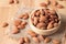 Almond seeds in a bowl wood on the sackcloth on table wooden background