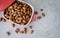 Almond snack fruit in red bowl on white background.