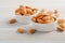 Almonds in a bowls on a white wooden background.