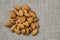 Almonds in detail. Handful or portion of almonds on jute fabric in top view