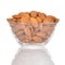 Almonds in a glass bowl on white background.