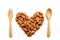 Almonds heart shape pattern with wooden fork and spoon.