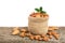 Almonds with leaf in bag from sacking on a wooden table with a white background