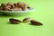 Almonds are not cleaned. In the center of a white plate are nuts. Three almond nuts lie separately on a yellow background. Food. A