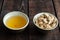 Almonds in nutshell and tea in cup on wooden background