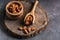 Almonds in a wooden scoop and a bowl on a stump cutting board. Selective focus