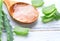 Aloe Vera gel closeup on white wooden background. Organic sliced aloevera leaf and gel, natural organic cosmetic ingredients