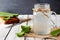 Aloe vera juice in a mason jar, side view on white wood