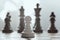 Alone against everyone, chess white pawl against opposite army on gray background.
