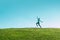 Alone asian Woman Jumping for Joy on a Grass Hill above horizon line One happy slim girl fly in a green field against blue summer