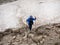 Alone brave woman with batons for hiking crosses a glacier in the mountains