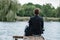 Alone businessman sitting on pier, lost island