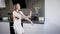 Alone crazy brunette woman is wearing pajamas and dancing in kitchen in evening, shaking her hands and body