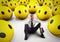 Alone desperate businessman in the middle of happy smileys . 3D Rendering