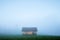 Alone house on foggy meadow