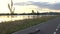 Alone longboard on asphalt road path on river bank in sunset in park out of city with skyline