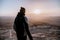 Alone man in israel negev desert admires the view of sunrise. Young male person stands on the edge of the cliff