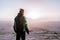 Alone man in israel negev desert admires the view of sunrise. Young male person stands on the edge of the cliff