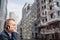 Alone middle-aged gray-haired businessman in a blue suit calling by phone standing on the empty city street.