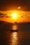 Alone sailboat at sunset. Atmospheric seascape with orange sun.