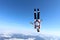 Alone skydiver is falling above snowy ground.