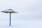 The alone sunshade or the parasol on the winter beach under the snow