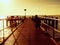 Alone tourist takes photos with camera and tripod on wooden pier