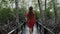 Alone Tourist Walks on Bridge and Enjoying Nature in Park with Mangrove Trees