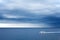 Alone white boat on sea and stormy sky