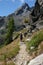 Alone woman along forest path in mountain - girl hiking