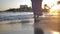 Alone woman in a skirt walks along the coastline in windy weather at sunset, skirt develops in the wind, slow motion