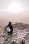 Alone young girl with backpack in israel negev desert admires the view of sunrise. Young female person stands on the edge