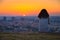 Alone young girl sitting over city and looking at calm summer sunset