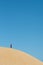 Alone young male asian standing on top of sand dune.