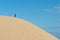 Alone young male asian standing on top of sand dune.