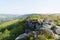 Along the gritstone of Baslow Egde to a distant, hazy, Curbar Edge