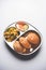 Aloo Fry OR Bombay potatoes and puri/Poori in a stainless steel oval plate