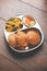 Aloo Fry OR Bombay potatoes and puri/Poori in a stainless steel oval plate