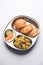 Aloo Fry OR Bombay potatoes and puri/Poori in a stainless steel oval plate