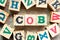 Alphabet block in word COB abbreviation of close of business with another on wood background