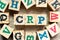 Alphabet block in word CRP abbreviation of C-Reactive Protein Test with another on wood background