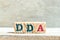 Alphabet block in word DDA Abbreviation of Depreciation, depletion and amortization or demand deposit account on wood